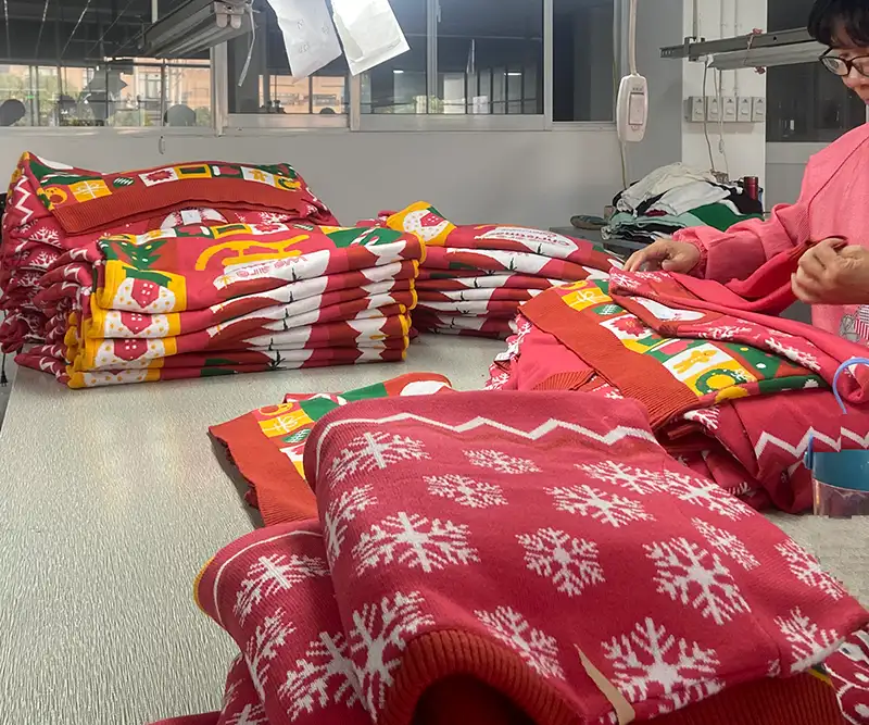 Factory workers inspecting custom Christmas sweaters
