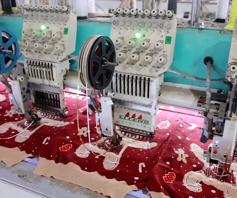 Close-up of embroidery machine stitching detailed Christmas design on sweater