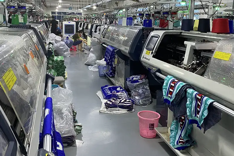 computerized knitting machines producing custom Christmas sweaters in bulk