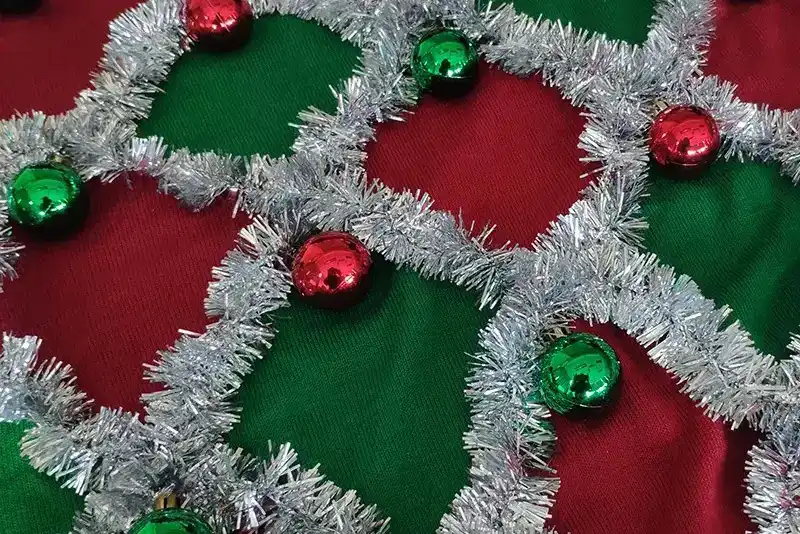 Ribbon and tinsel decoration on custom Christmas sweater