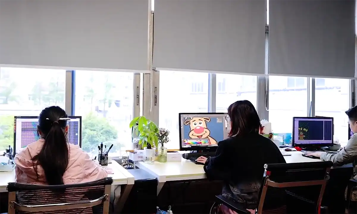 Factory designer creating Christmas sweater design on computer